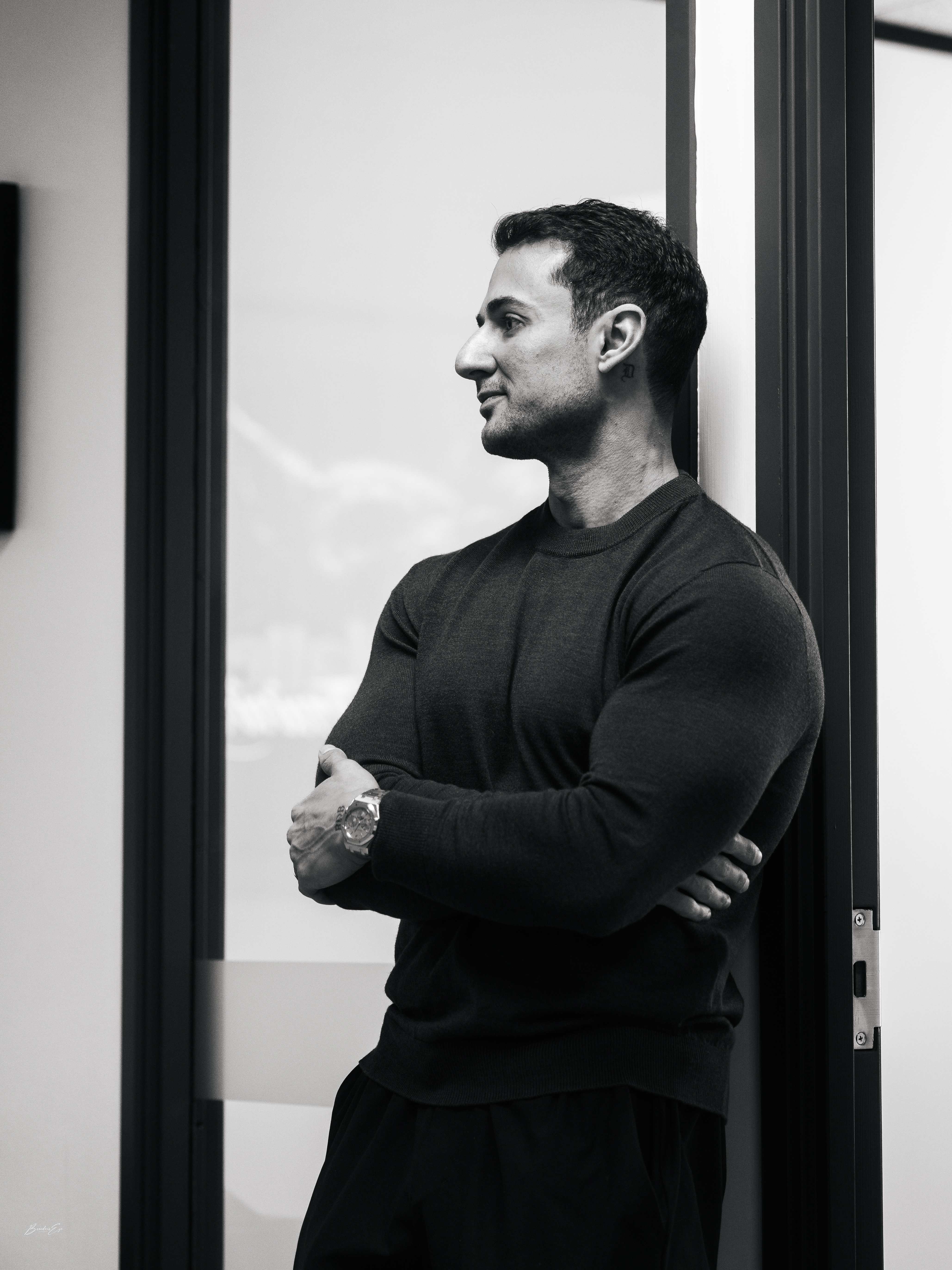 Dominic Kuza standing in a doorway with arms crossed